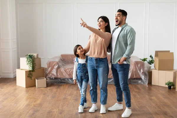 Щаслива мусульманська сім'я купує нову квартиру, вказуючи — стокове фото
