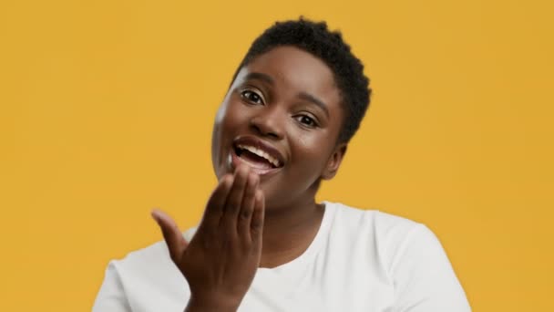 Plus-size zwarte vrouw die Air Kiss naar de camera stuurt, gele achtergrond — Stockvideo