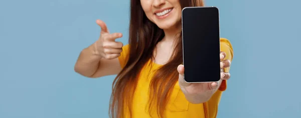 Junge Frau zeigt Smartphone mit leerem Bildschirm — Stockfoto