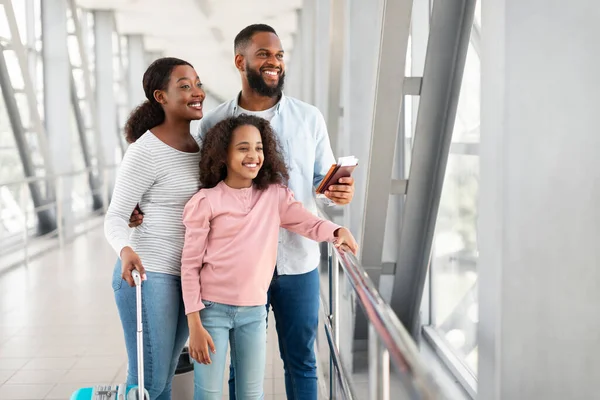 Black family travelling, waiting for the aircraft arrival