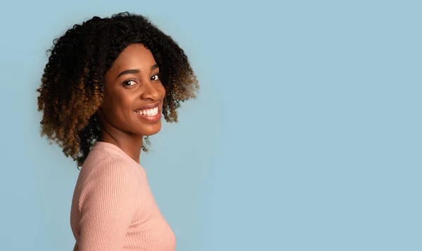 Mujer negra feliz. Sonriente joven afroamericana posando sobre fondo azul —  Fotos de Stock