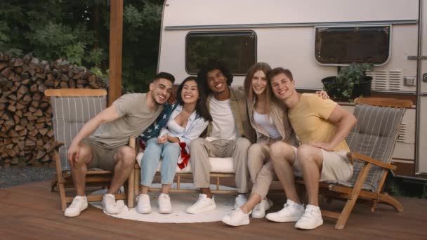 Группа весёлых мультикультурных друзей позирует рядом с современным Камперваном в кемпинге — стоковое видео