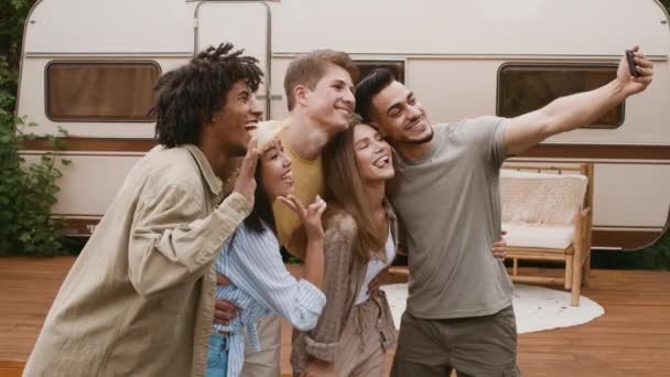 Группа мультикультурных друзей улыбается и делает селфи на смартфоне в кемпинге — стоковое видео