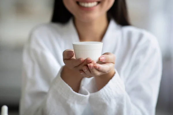 Gehaakt van vrouw in badjas met witte pot met room — Stockfoto