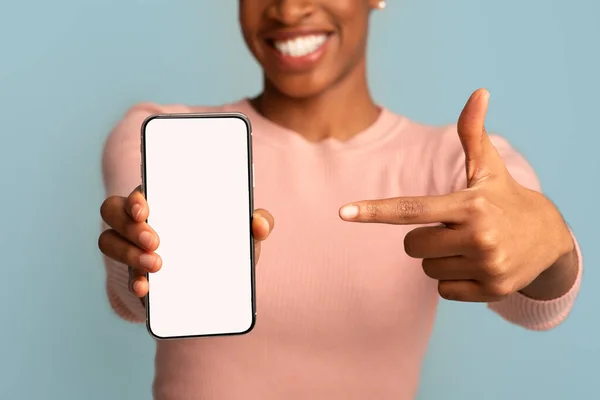 手拿着空白白屏在智能手机上指指点点的黑人女士 — 图库照片