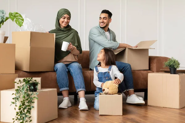Happy islamic family packing or unpacking boxes