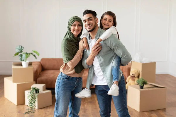 Счастливая мусульманская семья смотрит в камеру, позирует в новой квартире — стоковое фото