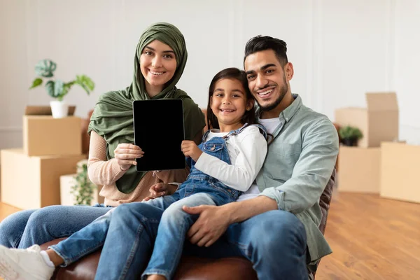 Счастливая мусульманская семья делает ремонт в новом доме с помощью планшета — стоковое фото