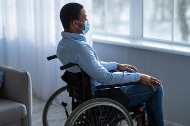 Ev hapsi sırasında depresyon geçiren maskeli bir siyahi adam.