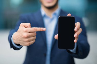 Tanımlanamayan işadamı boş ekran ile akıllı telefonu işaret ediyor
