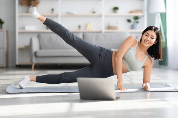 Online Training. jong mooi aziatisch vrouw doen sport met laptop thuis — Stockfoto