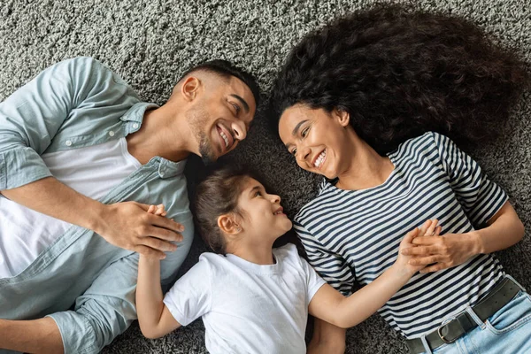 손을 잡고 카펫 위에 누워 사랑하는 가족이 누워 있는 모습 — 스톡 사진