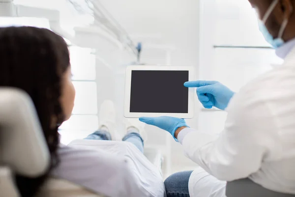Μαύρο Οδοντίατρος Εμφάνιση Ψηφιακή ταμπλέτα με κενή οθόνη για τη γυναίκα ασθενή — Φωτογραφία Αρχείου