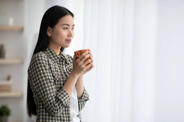 Fair hair aziatische dame genieten ochtend koffie in de woonkamer — Stockfoto