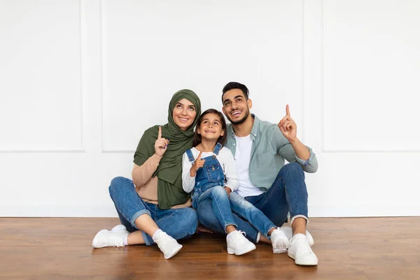 Uomo, donna e ragazza felici che puntano il dito verso casa — Foto Stock