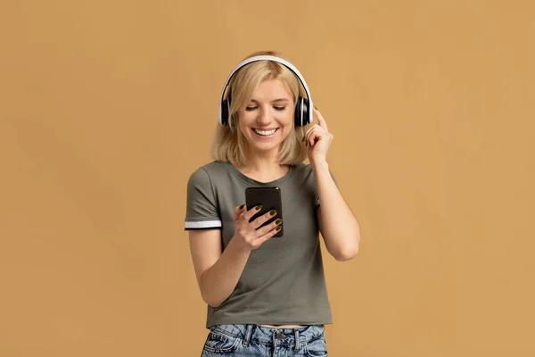 Lazer favorito. Mulher milenar feliz em fones de ouvido sem fio ouvir música on-line no smartphone — Fotografia de Stock