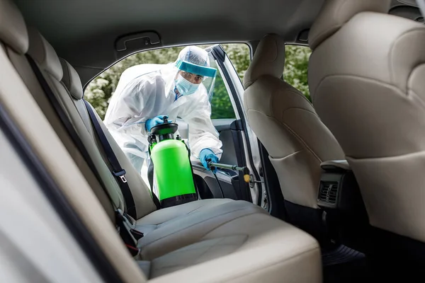 Specialist schoonmaker draagt hazmat suite, persoonlijke beschermingsmiddelen PBM met behulp van chemische alcohol spray — Stockfoto