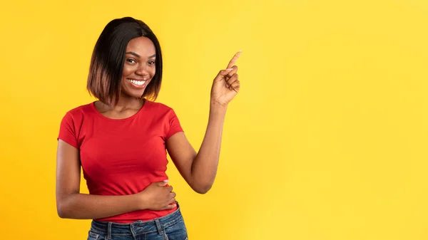 Afro-americano mulher apontando dedo fora sobre fundo amarelo — Fotografia de Stock