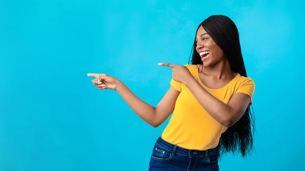 Alegre afro-americano senhora apontando dedos fora sobre fundo azul — Fotografia de Stock