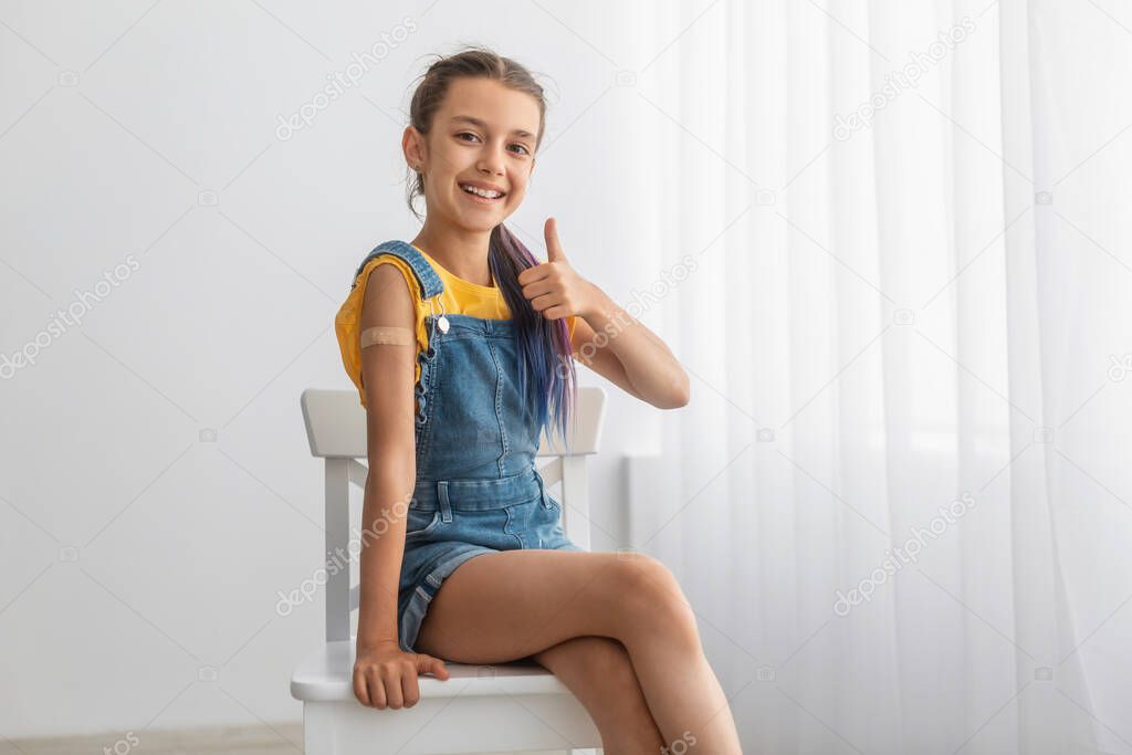 Teen Girl Showing Vaccinated Arm And Thumbs Up