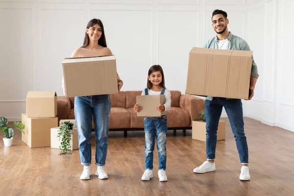 Щаслива молода сім'я з трьох тримає коробки в новій квартирі — стокове фото