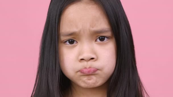 Kid nycker. Närbild porträtt av asiatisk flicka sura läppar, känna sig upprörd och förolämpad, fick inte vad hon ville — Stockvideo