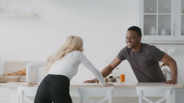 Multietniskt par som har roligt att spela fånga varandra i köket — Stockvideo
