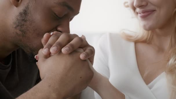 Liefdevolle zwarte man zoenen vrouwen hand zitten binnen, close-up — Stockvideo