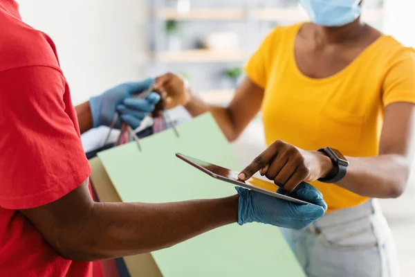 Kunde erhält Taschen vom Kurierdienst beim Scannen von Fingerabdrücken auf Tablet — Stockfoto