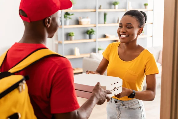 Afroamerikanerin erhält Pizzakartons vom Kurier — Stockfoto