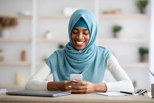 Ofiste akıllı telefon kullanan gülümseyen Afrikalı İslamcı Kadın Portresi — Stok fotoğraf