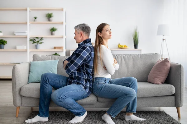 Pareja casada de mediana edad sentada espalda con espalda en el sofá, no hablando entre sí después de un conflicto en casa — Foto de Stock