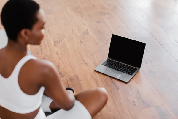 Молода чорна жінка сидить на килимку з ПК — стокове фото
