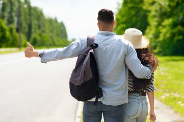 Otostop çeken, yolda duran bir çift.