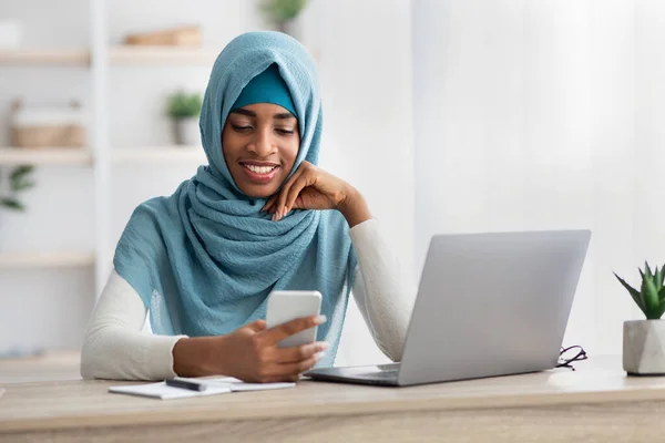 Fekete iszlám üzleti hölgy Hidzsáb használata okostelefon, miközben dolgozik az irodában — Stock Fotó