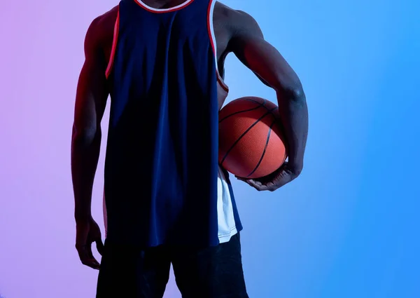 Pemandangan dari basketballer hitam muda memegang bola dalam lampu neon, closeup — Stok Foto