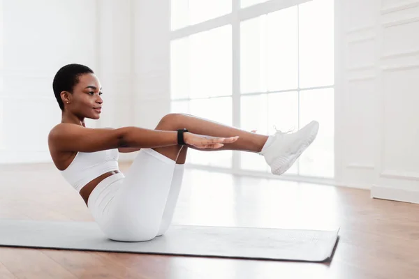 Yoga minderi üzerinde Crunches egzersizi yapan odaklanmış siyah bir kadın. — Stok fotoğraf