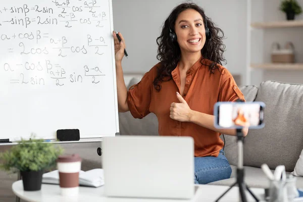 Bayan öğretmen el hareketi yapıyor, öğrencilere matematiği anlatıyor.