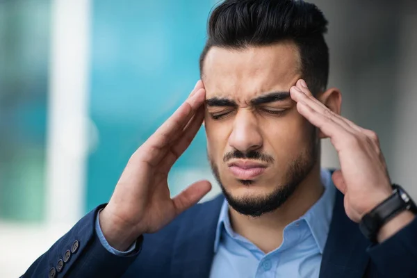 Hombre de negocios árabe joven estresado que sufre de dolor de cabeza — Foto de Stock