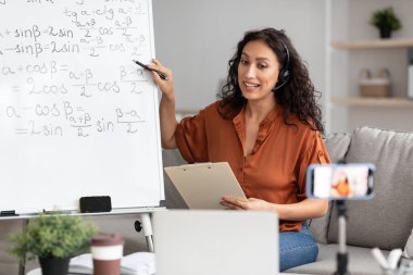 Video kaydeden öğrencilere çevrimiçi konferans veren bayan öğretmen