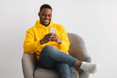 Smartphone 'da Gri Arkaplanda Yeni Uygulama Kullanan Mutlu Siyah Adam