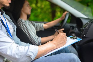 Erkek eğitmen, bayan öğrenciyi muayene ediyor.