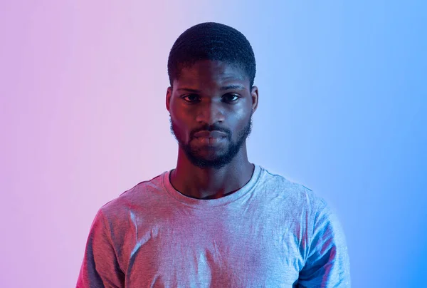 Porträtt av stilig svart idrottsman i sport t-shirt tittar på kameran i neonljus. Begreppet aktiv livsstil — Stockfoto