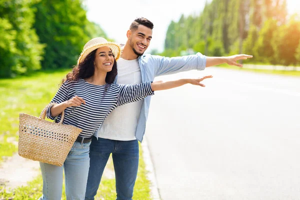 Casal multirracial hitchiking, parar de carro na estrada — Fotografia de Stock