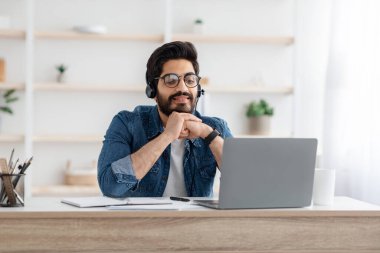 Ders, Covid sırasında Webinar. Kulaklıklı ve gözlüklü mutlu Arap çocuk laptop ekranına bakıyor, boşluğu kopyala