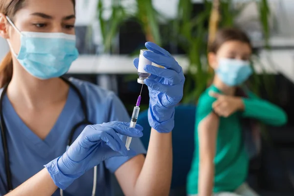 Krankenschwester mit Spritze, die Covid-19-Impfstoff aus Ampulle nimmt — Stockfoto