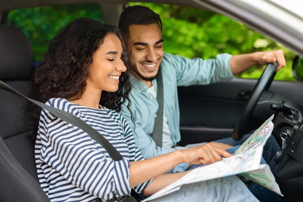 Glückliches Paar aus dem Nahen Osten sitzt im Auto und plant die Reise — Stockfoto