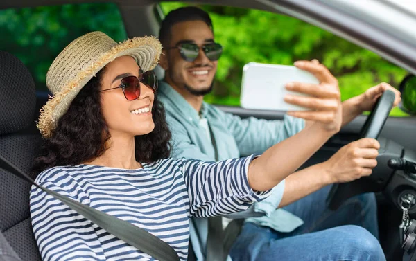 Bella giovane coppia prendendo selfie dentro auto — Foto Stock