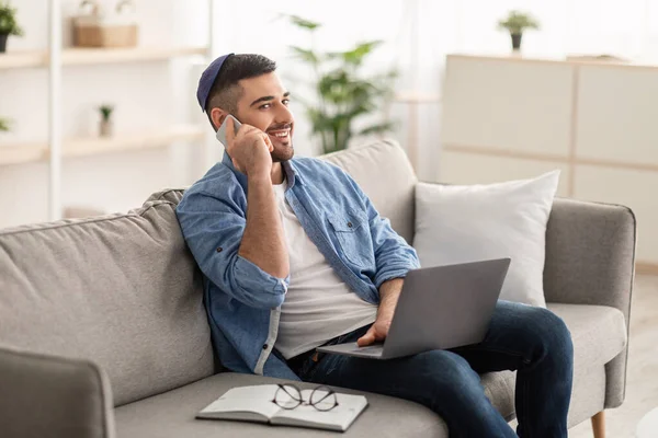 Homme travaillant sur PC et parlant sur téléphone portable à la maison — Photo