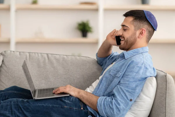 Homme travaillant sur PC et parlant sur téléphone portable à la maison — Photo